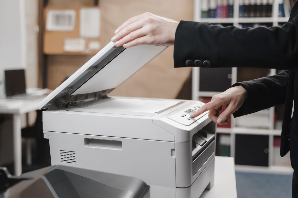 Une femme d'affaires utilise l'imprimante pour scanner et imprimer des documents.